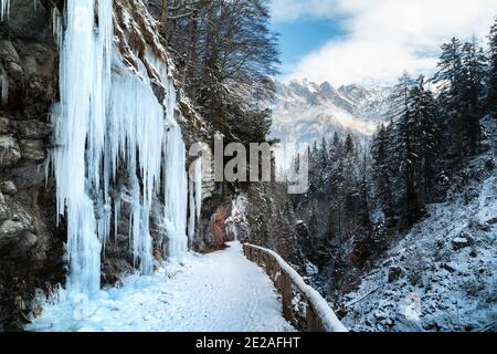 Magnifique vue panoramique sur un paysage idyllique d'hiver et de merveilles avec des glaçons Et sentier le long d'un canyon escarpé dans les Alpes une journée d'hiver froide et ensoleillée Banque D'Images