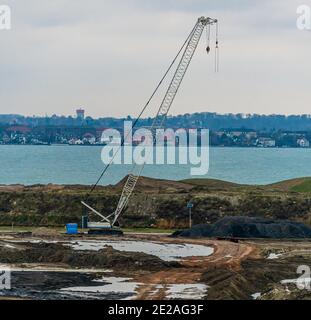 Grande grue de construction industrielle sur un chantier près de la mer. Banque D'Images