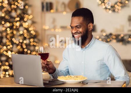 Homme noir ayant le dîner de boire du vin de fabrication videocall Banque D'Images