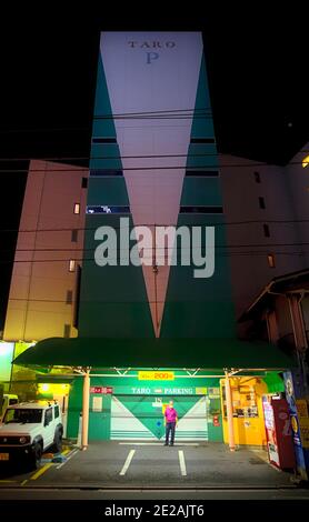 Setagaya, Tokyo, Japon - septembre 10 2020 : vue de nuit d'un ancien gardien de parking d'âge moyen debout seul au pied d'un parking towe Banque D'Images