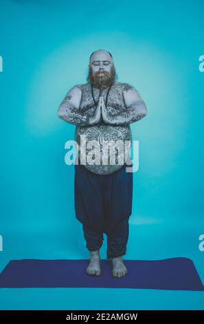 Hipster homme avec tatouages faire des exercices de yoga et de méditation dans le matin Banque D'Images