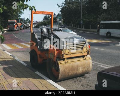 Russie, Sotchi 05.07.2020. Le rouleau vibrant est stationné sur le côté de la route, à côté du passage pour piétons Banque D'Images