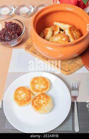 Crêpes au fromage cottage dans une assiette et un pot d'argile, avec confiture sur une table de serveurs délicieux dessert au fromage cottage. Photo de haute qualité Banque D'Images