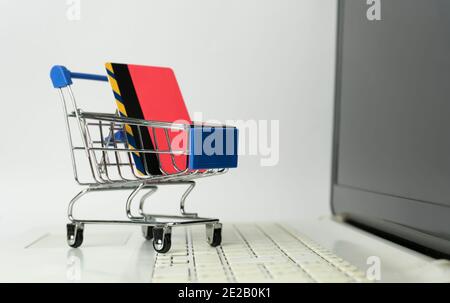 Achat en ligne concept.supermarché mini chariot avec une carte de crédit bancaire sur le clavier d'ordinateur portable.E-commerce , banque sur Internet et payer par crédit c Banque D'Images