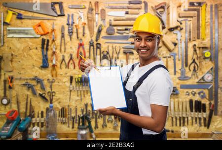 happy builder en casque avec presse-papiers et crayon Banque D'Images