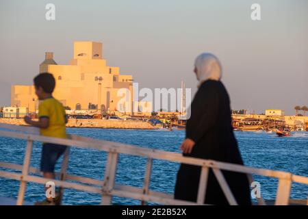 Qatar, Doha, mère et enfant à bord d'un bateau, Musée d'art islamique en arrière-plan Banque D'Images