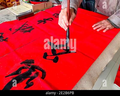 Un calligraphe est en train de créer et d'écrire les couplets du Festival de printemps, le Festival de printemps du nouvel an chinois Banque D'Images