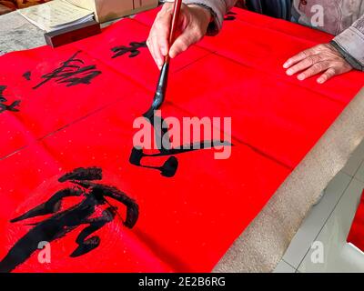 Un calligraphe est en train de créer et d'écrire les couplets du Festival de printemps, le Festival de printemps du nouvel an chinois Banque D'Images