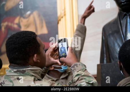 Les membres de la Garde nationale prennent des photos de la statue de Martin Luther King Jr., dans la rotonde au capitole des États-Unis, alors que la Chambre des représentants vote sur H. Res. 24, destitution de Donald John Trump, président des États-Unis, pour crimes et délits graves, au Capitole des États-Unis à Washington, DC, le mercredi 13 janvier 2021. Crédit : Rod Lamkey/CNP | utilisation dans le monde entier