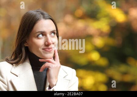 Portrait d'une femme satisfaite regardant à côté dans un parc en automne Banque D'Images