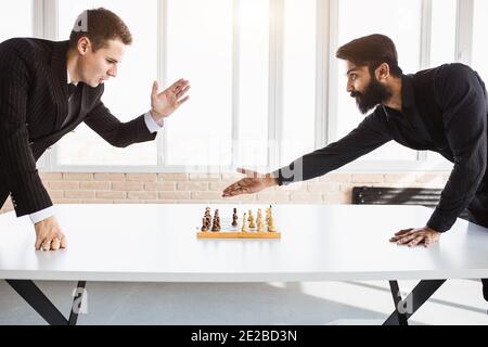deux hommes d'affaires, rivaux, jouent aux échecs. Stratégie et rivalité. Banque D'Images