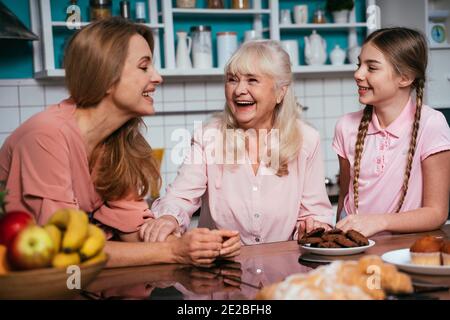 Image Cinematic d'une femme âgée et de sa fille et petite-fille qui cuisinait et préparait de la nourriture dans sa belle cuisine. Grand-mère préparant des gâteaux an Banque D'Images