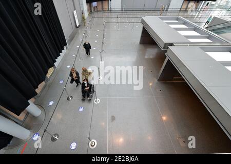 Un membre de la Garde nationale de New York aide une femme en fauteuil roulant à la zone de distribution du vaccin COVID-19 à l'intérieur du Centre de congrès Jacob K. Javits qui ouvre aujourd'hui le site de vaccination COVID-19 géré par l'État, à New York, NY, le 13 janvier 2021. Autrefois utilisé comme hôpital de traitement sur le terrain du coronavirus en mars 2020 lors de la première vague d'infections à COVID-19, le centre Jacob Javits sera maintenant utilisé pour accélérer encore la distribution des vaccins à New York; L'État de New York est actuellement en phase 1B, avec une priorité de vaccination pour les travailleurs de la santé, les personnes âgées de 65 ans et plus, les premiers Banque D'Images