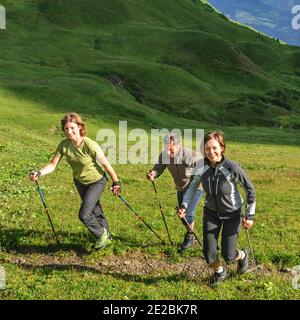 Jeunes sportifs faisant une séance de marche nordique dans la nature alpine Banque D'Images