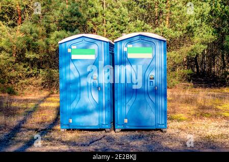 Deux cabines de toilette en plastique bleu. toilettes publiques dans le parc de la ville. Maison de toilette chimique sur un chantier de construction. Toilettes bio dans l'espace de loisirs. Banque D'Images