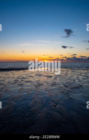 Vue sur le soleil couchant qui brille sur la mer et se reflète sur la plage, nuages avec des bords ensoleillés. Paysage. Photo de haute qualité montrant le concept de liberté et de rêves Banque D'Images