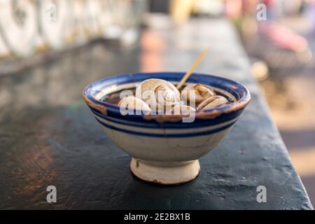 Bol de soupe d'escargots, aromatisé avec une concoction d'environ 15 épices, dans une cabine à Marrakech, au Maroc Banque D'Images