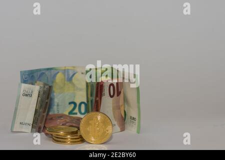 beaucoup de billets différents en euros avec des bitcoins d'or et fond gris Banque D'Images