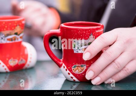 Réchauffer avec du vin chaud.gros plan de la femme tenant une tasse de verre de Délicieux vin chaud blanc dans ses mains.UNE fille tient un tasse de vin chaud dans sa main Banque D'Images