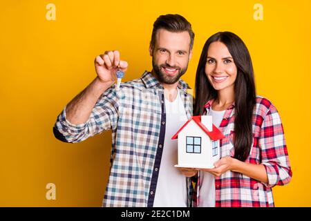 Photo portrait de l'homme tenant des clés femme avec modèle à la maison isolé sur un arrière-plan jaune vif Banque D'Images