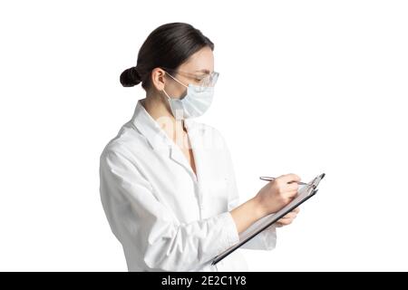 Jeune femme médecin remplissant un rapport isolé sur fond blanc Banque D'Images