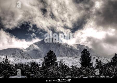 Paysage alpin avec tempête de neige et paysage de nuages spectaculaires sur les montagnes de Retezat. Photo prise le 2 février 2020 dans le parc national de Retezat, Roumanie. Banque D'Images