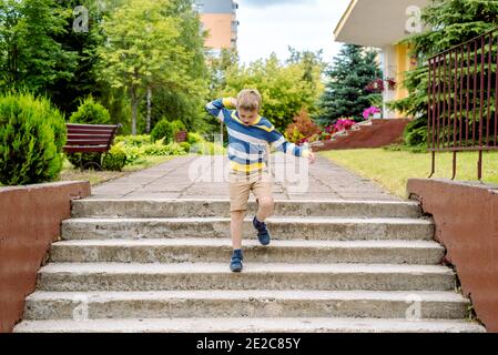 Portrait d'un écolier avec sac à dos bondissant . le garçon court un sac à dos autour de la cour d'école.enfance, concept d'apprentissage de l'éducation Banque D'Images