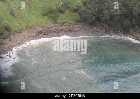 Lavage d'huile sur le rivage de Tauranga, Nouvelle-Zélande, le 12 octobre 2011. Le Rena, un bateau à conteneurs de 47,000 tonnes, a frappé mercredi un récif, provoquant une fuite de pétrole qui s'est étendue sur cinq kilomètres. Les autorités se préparent à la pire catastrophe environnementale de l'histoire de la Nouvelle-Zélande si le navire se brise et déverse 1,700 tonnes de carburant dans la baie de Plenty. Photo de Maritime New Zealand/ABACAPRESS.COM Banque D'Images