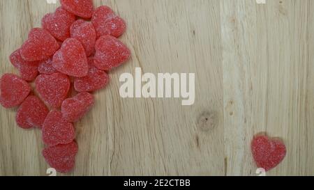 Les cœurs de bonbons à la cannelle rouge forment une bordure sur un fond en bois avec un espace pour un message de la Saint-Valentin. Banque D'Images