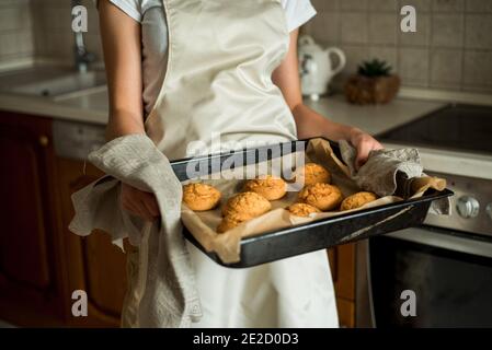 une fille dans la cuisine prend des biscuits chauds et du pain d'épice du four. gâteaux faits maison, sucreries et tartes. cuisson maison, vie domestique Banque D'Images