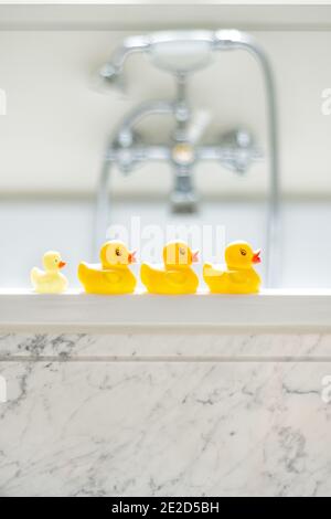 Photo sélective de canards de bain en caoutchouc jaune mignons une rangée dans une salle de bains Banque D'Images