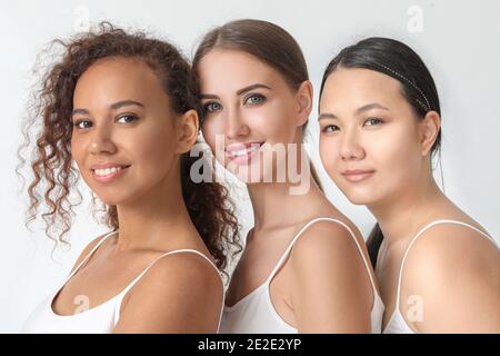 Portrait de belles jeunes femmes avec différentes teintes de peau sur fond clair Banque D'Images