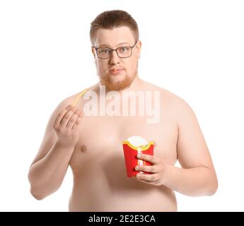 Un homme en surpoids stressé mangeant des frites malsaines sur fond blanc. Concept de perte de poids Banque D'Images