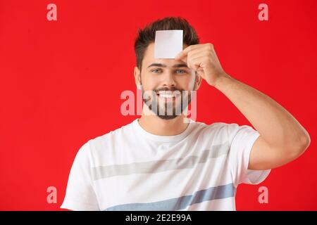 Homme avec papier vierge sur fond de couleur Banque D'Images