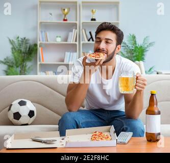 Le man eating pizza à emporter à la maison avoir un repos relaxant Banque D'Images