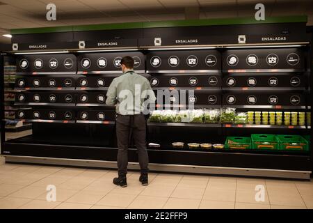 Madrid, Espagne. 13 janvier 2021. Un homme se tient devant la tablette dans un supermarché à Madrid, Espagne, le 13 janvier 2021. Mardi, le gouvernement espagnol a confirmé la mort de cinq personnes liées à la tempête Filomena, qui a entraîné des chutes de neige record dans le centre et l'est de l'Espagne et des inondations dans certaines parties du sud du pays. Credit: Meng Dingbo/Xinhua/Alay Live News Banque D'Images