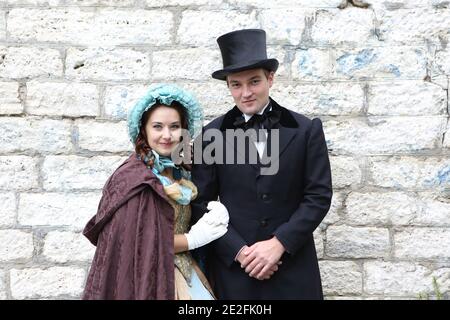 Homme et femme en costumes du XIXe siècle marcher dans le stationnement Banque D'Images