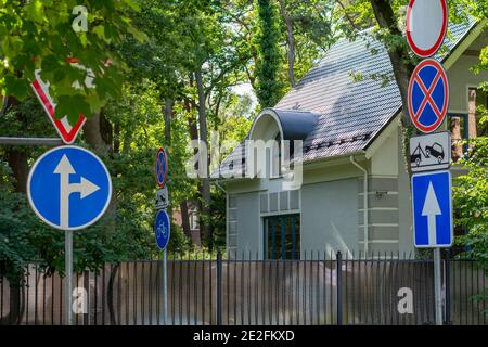 Beaucoup de panneaux de signalisation sur la petite rue près de la maison privée. Concept de sécurité routière. Mise au point sélective. Banque D'Images