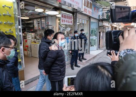 Hong Kong, Chine. 14 janvier 2021. Le conseiller de district et avocat Daniel Wong Kwok-tung est escorté par des policiers lorsqu'il quitte son bureau. Wong aurait été arrêté par des agents de la police de sécurité nationale pour avoir aidé douze manifestants de Hong Kong dans leur tentative d'évasion à Taiwan en août dernier. Crédit : SOPA Images Limited/Alamy Live News Banque D'Images