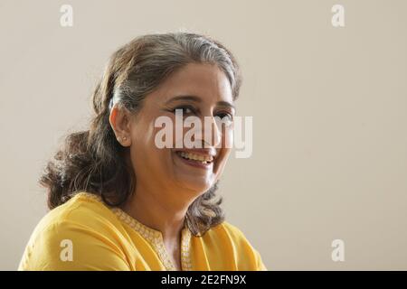 UNE FEMME ADULTE REGARDANT L'APPAREIL PHOTO ET SOURIANT Banque D'Images
