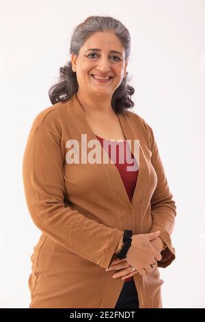 UNE FEMME HEUREUSE DEBOUT ET SOURIANTE GAIEMENT Banque D'Images