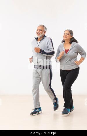 UN COUPLE SENIOR QUI FAIT DU JOGGING ENSEMBLE EST HEUREUX Banque D'Images