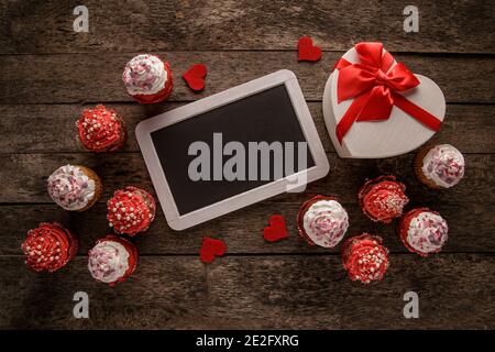Carte de vœux de Saint-Valentin avec délicieux petits gâteaux sucrés et boîte cadeau sur fond de bois. Vue de dessus, espace de copie Banque D'Images