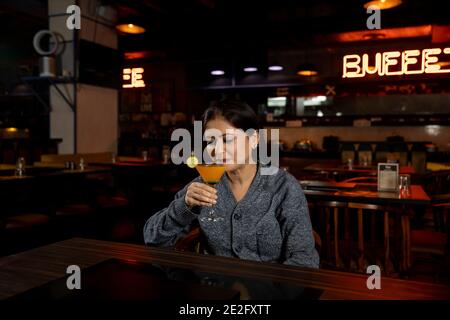 Portrait d'une femme avec un verre de jus dans un restaurant. Banque D'Images