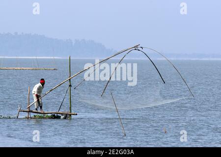 Pêcheur avec filet sur le fleuve Brahmaputra, Assam, Inde Banque D'Images