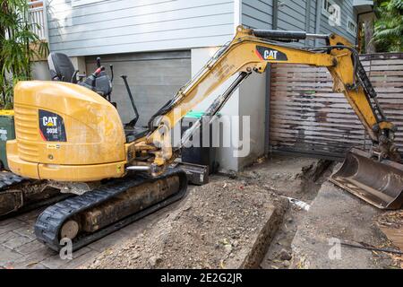 Minipelle hydraulique creusant une tranchée mécaniquement pour réparer une cassure Tuyau de drainage, Sydney, Australie Banque D'Images