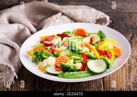 assiette de légumes sautés sur une table en bois Banque D'Images