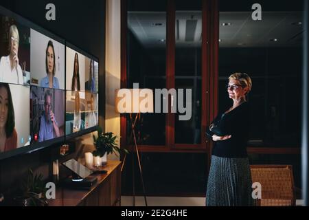 Équipe professionnelle multiethnique effectuant un appel vidéo la nuit. L'équipe internationale effectue une conférence téléphonique. Banque D'Images