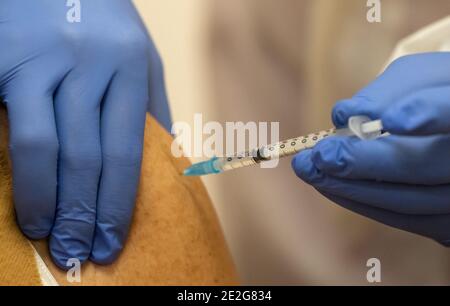 Weimar, Allemagne. 13 janvier 2021. Une femme âgée est vaccinée contre Corona avec le vaccin Biontech/Pfizer au centre de vaccination du centre jeunesse et culturel mon ami. Aujourd'hui, les premières pratiques de vaccination en Thuringe commencent leur travail. Au départ, seules les personnes prioritaires seront vaccinées, y compris les personnes âgées de plus de 80 ans et les employés des services de soins et de sauvetage. Credit: Michael Reichel/dpa-Zentralbild/dpa/Alay Live News Banque D'Images