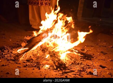 Éclairage de feu de joie pendant le festival Punjabi Lohri en Inde. Le festival Lohri marque la fin de la saison d'hiver et le début de journées plus longues Banque D'Images